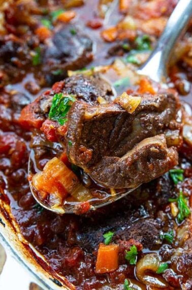 close up spoon of Osso Bucco from skillet