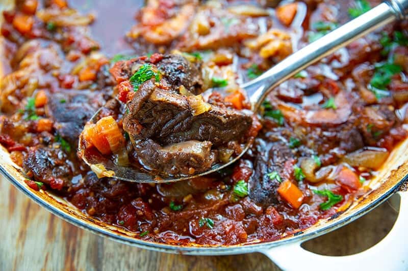 a spoon of Osso Bucco from skillet 