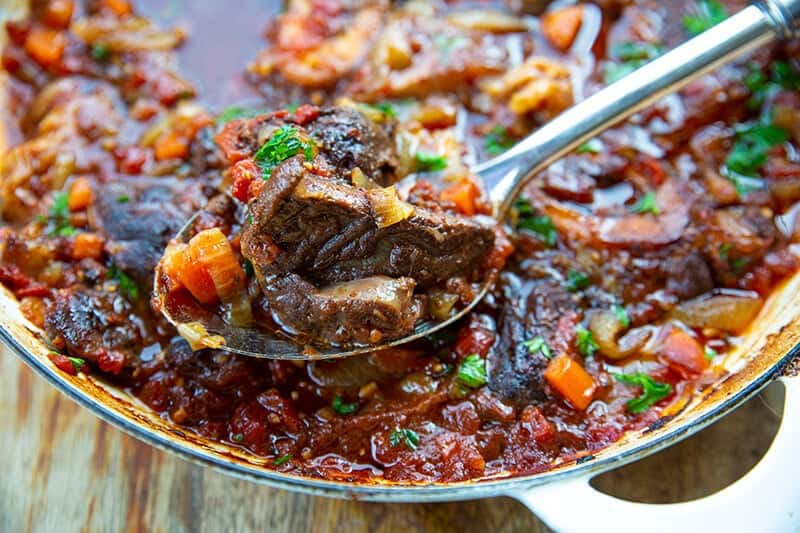 a spoon of Osso Bucco from skillet