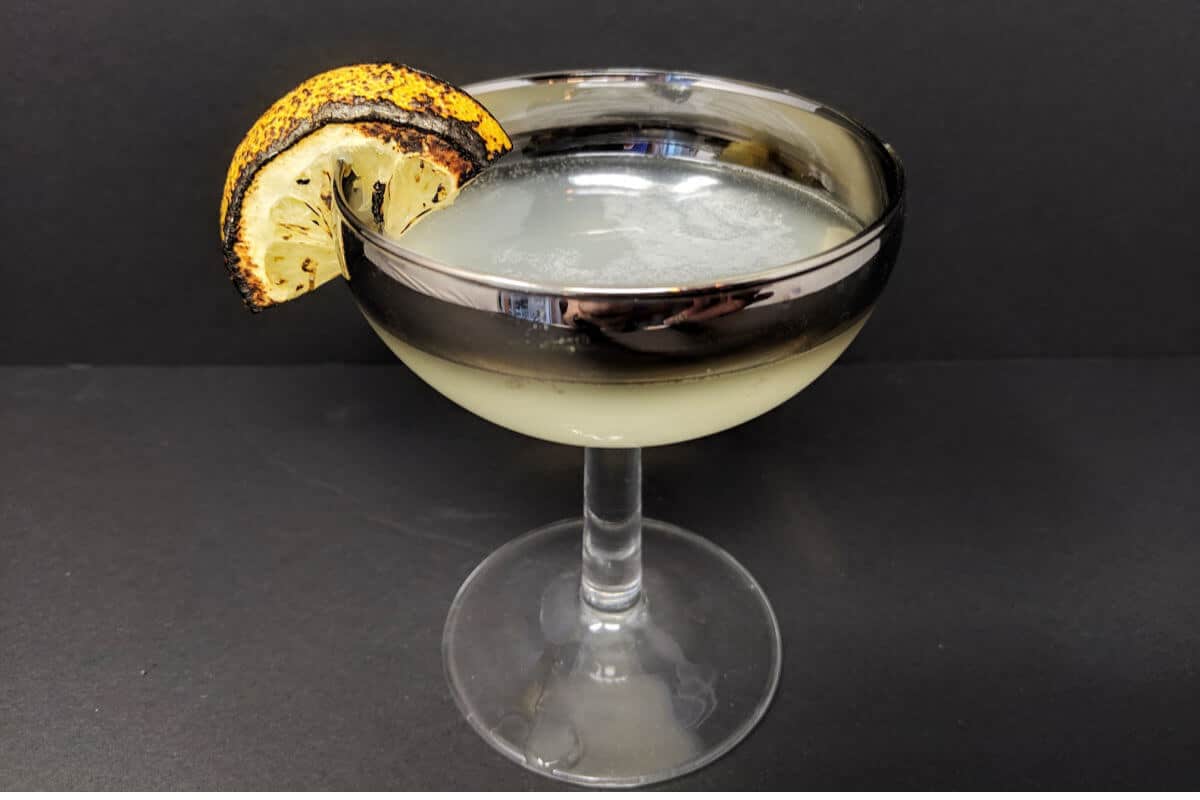 a coupe with Corpse Reviver garnish with a little bit burned lemon slice