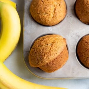 close up Banana Bread Muffins in muffin tins, rife bananas on background