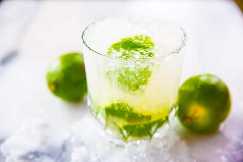 a glass of Caipirinha with crushed ice, garnish with lime