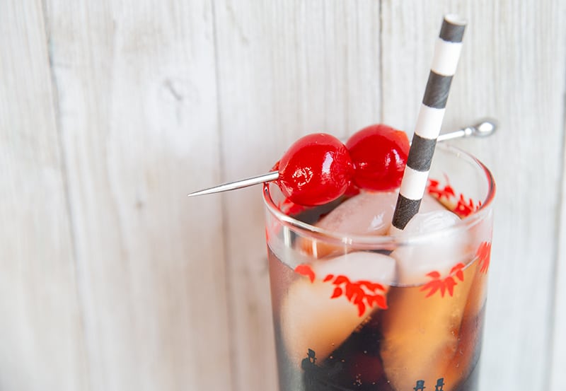 Roy Rogers drink in a tall vintage glass, garnish with two maraschino cherries