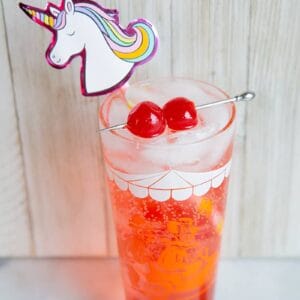 Shirley Temple drink with unicorn straw and garnish with maraschino cherries