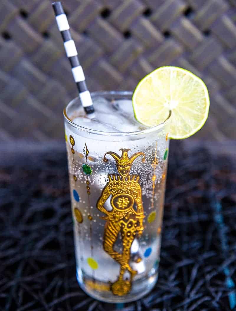 close up Vodka Soda in a Vintage Mardi Gras Glass garnish with a lime slice