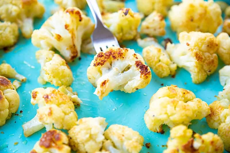 Buttery Garlic Roasted Cauliflower florets on blue background