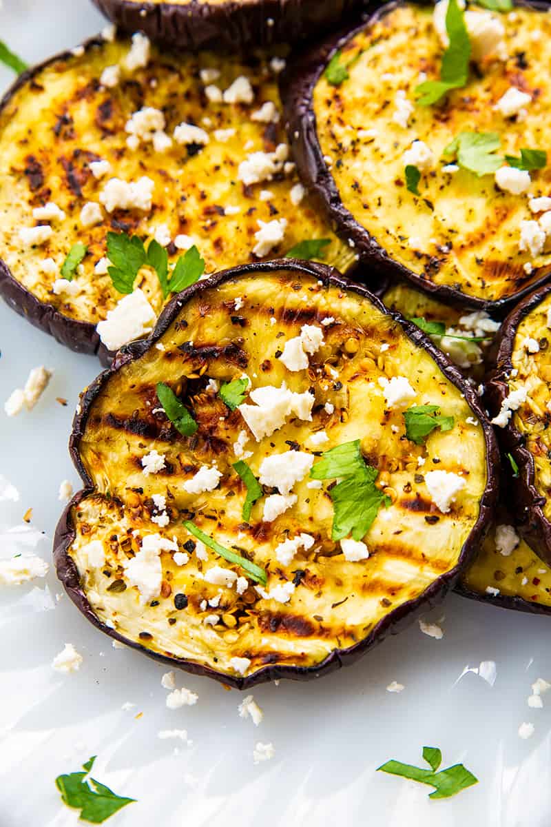close up sliced Grilled Eggplant with some some feta cheese and parsley