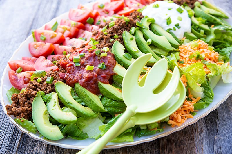 close up salad spoon fork in a platter of Ground Beef Taco Salad with ranch dressing