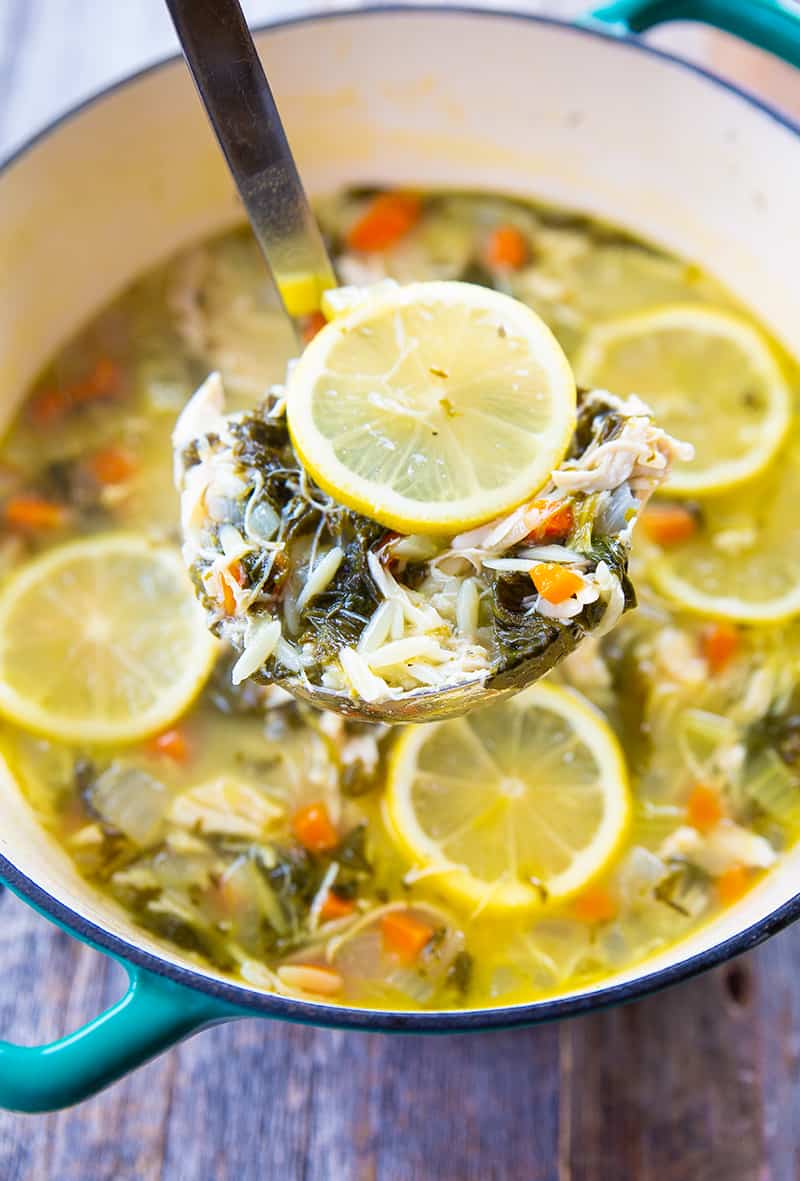 a scoop of Lemon Chicken Soup with Orzo in a large blue pot