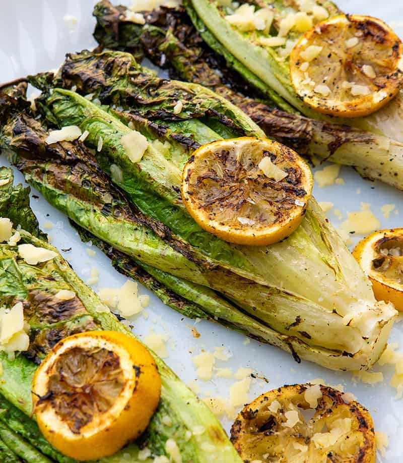 close up Parmesan Garlic Grilled Romaine with some lemon slices on top and parmesan garlic toppings