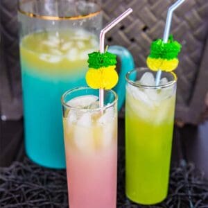 2 glasses and a large pitcher of Pineapple Prosecco Party Punch with ice cubes