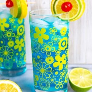 Two Electric Lemonade cocktails side by side in vintage flower glasses