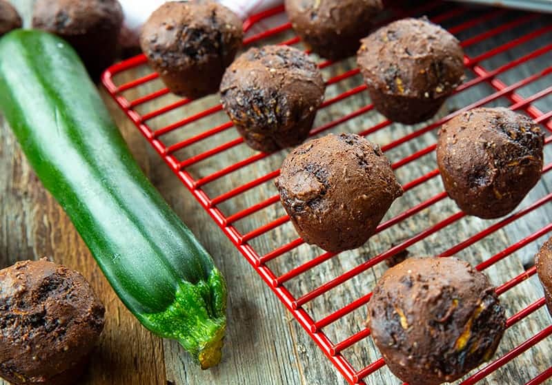 Brownie Bites in a red wire rack, whole zucchini beside it