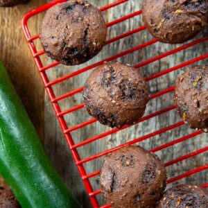 close up Brownie Bites in a red wire rack, whole zucchini beside it