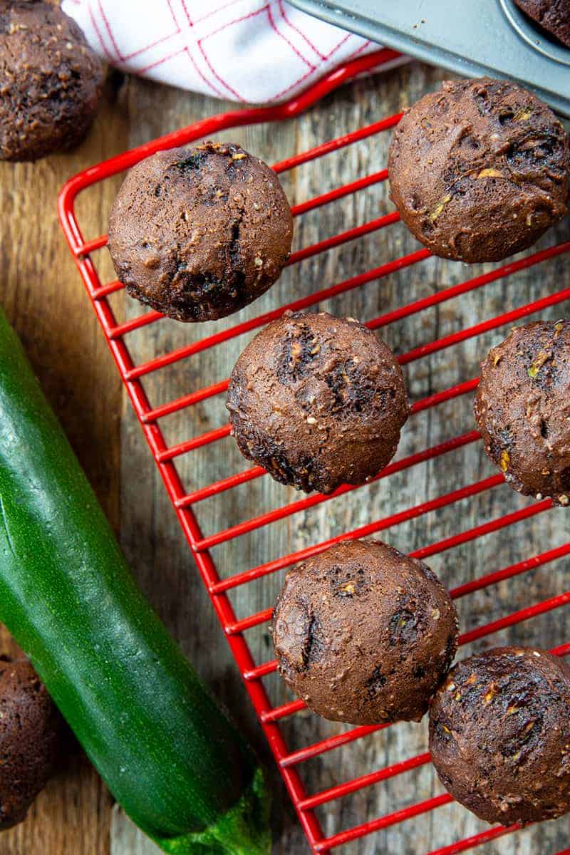 close up Brownie Bites in a red wire rack, whole zucchini beside it
