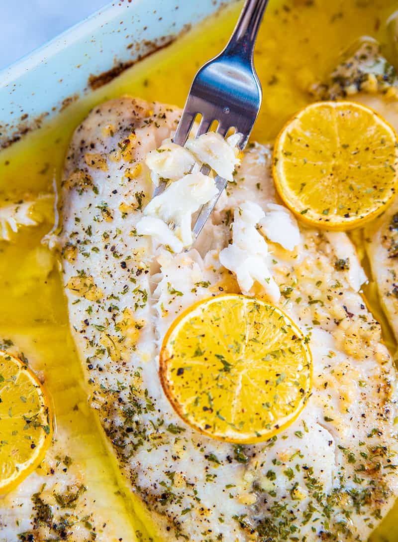 flaking cooked tilapia fillet using a fork