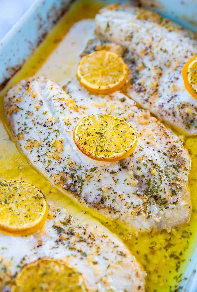 three baked tilapia fillets with lemon slices on top 