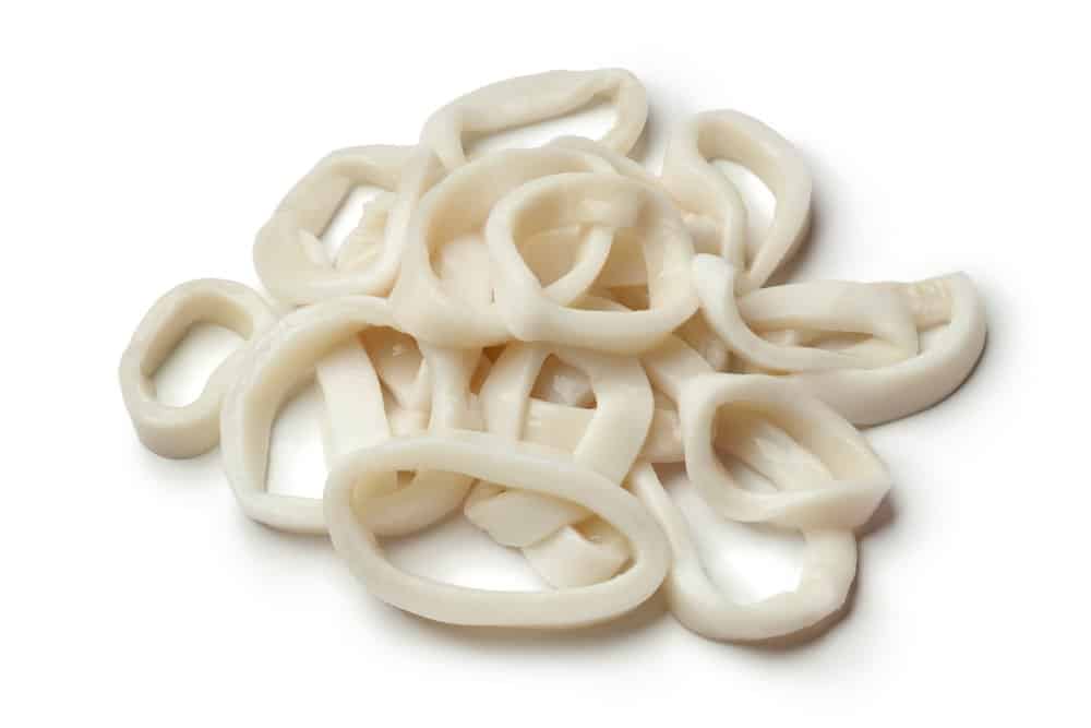 Heap of fresh raw calamari / squid rings on white background