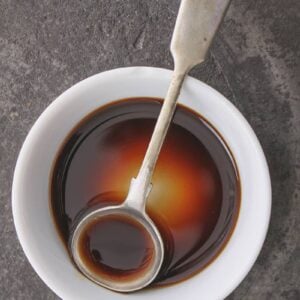 Worcestershire Sauce in a white cup with stir spoon