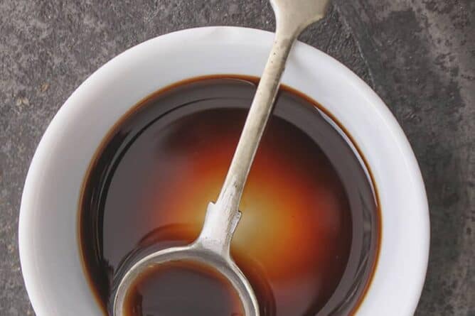Worcestershire Sauce in a white cup with stir spoon