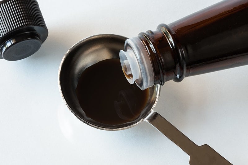 measuring a tablespoon of Worcestershire Sauce