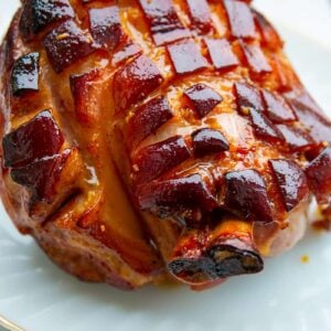 close up Brown Sugar Glazed Baked Picnic Ham in a gold line serving plate