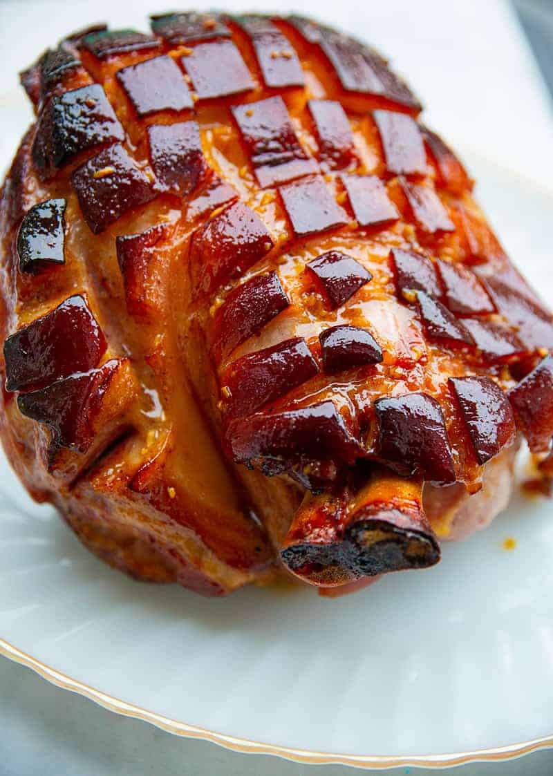 close up Brown Sugar Glazed Baked Picnic Ham in a gold line serving plate