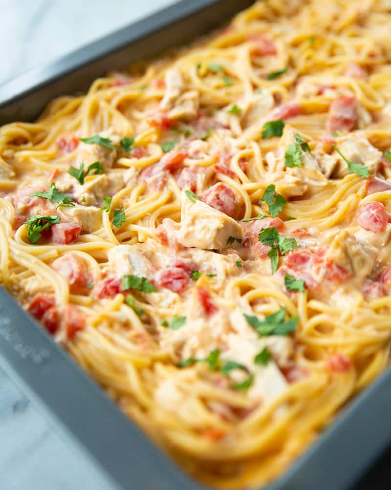 close up Cheesy Chicken Spaghetti in a pan with some parsley leaves