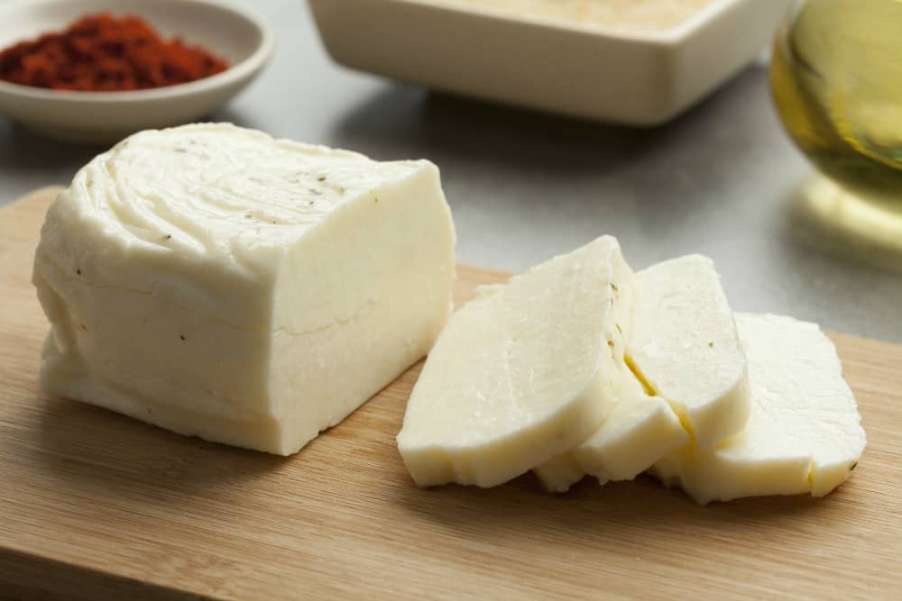 Piece of fresh sliced halloumi cheese on a cutting board