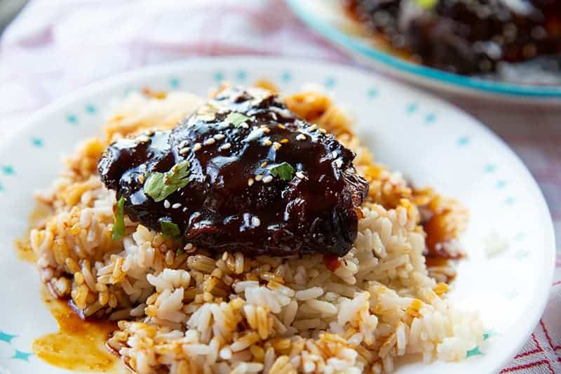 white plate with Instant Pot Chicken Thighs on rice with Honey Garlic sauce