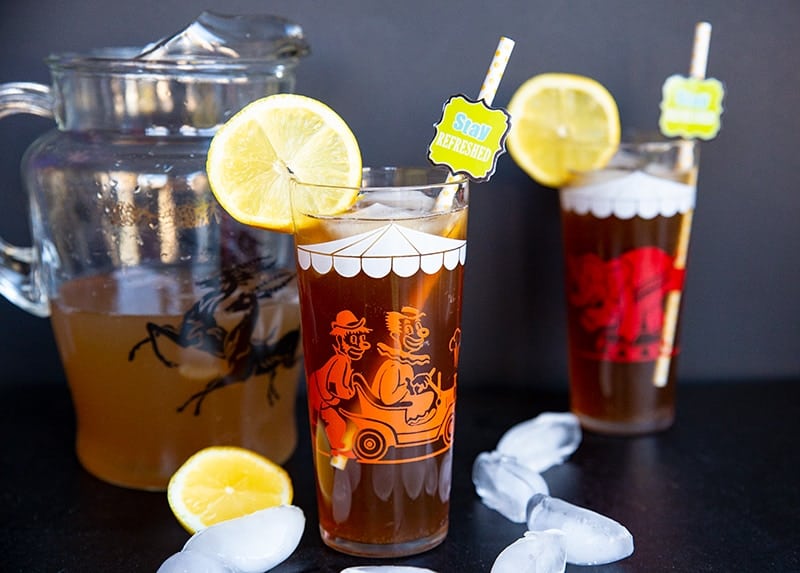 a pitcher and glasses of Long Island Iced Tea garnish with slices of lemon