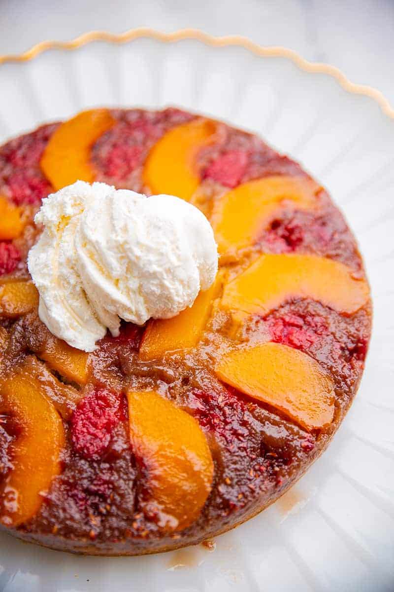 close up gold line dessert plate with Peach Upside Down Cake topped with a scoop of vanilla ice cream