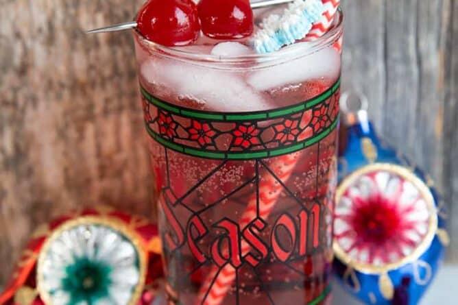 Sparkling vodka cranberry cocktail in a nice Christmas glass garnish with snowflakes and cherries