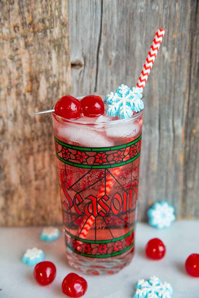 close up Sparkling vodka cranberry cocktail in a nice Christmas glass garnish with snowflakes and cherries