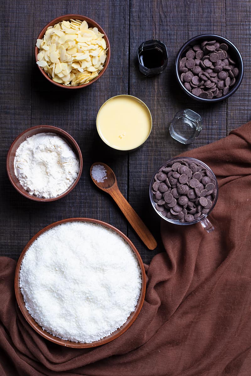 Almond Joy Cookie ingredients on wood background with brown tablecloth on side