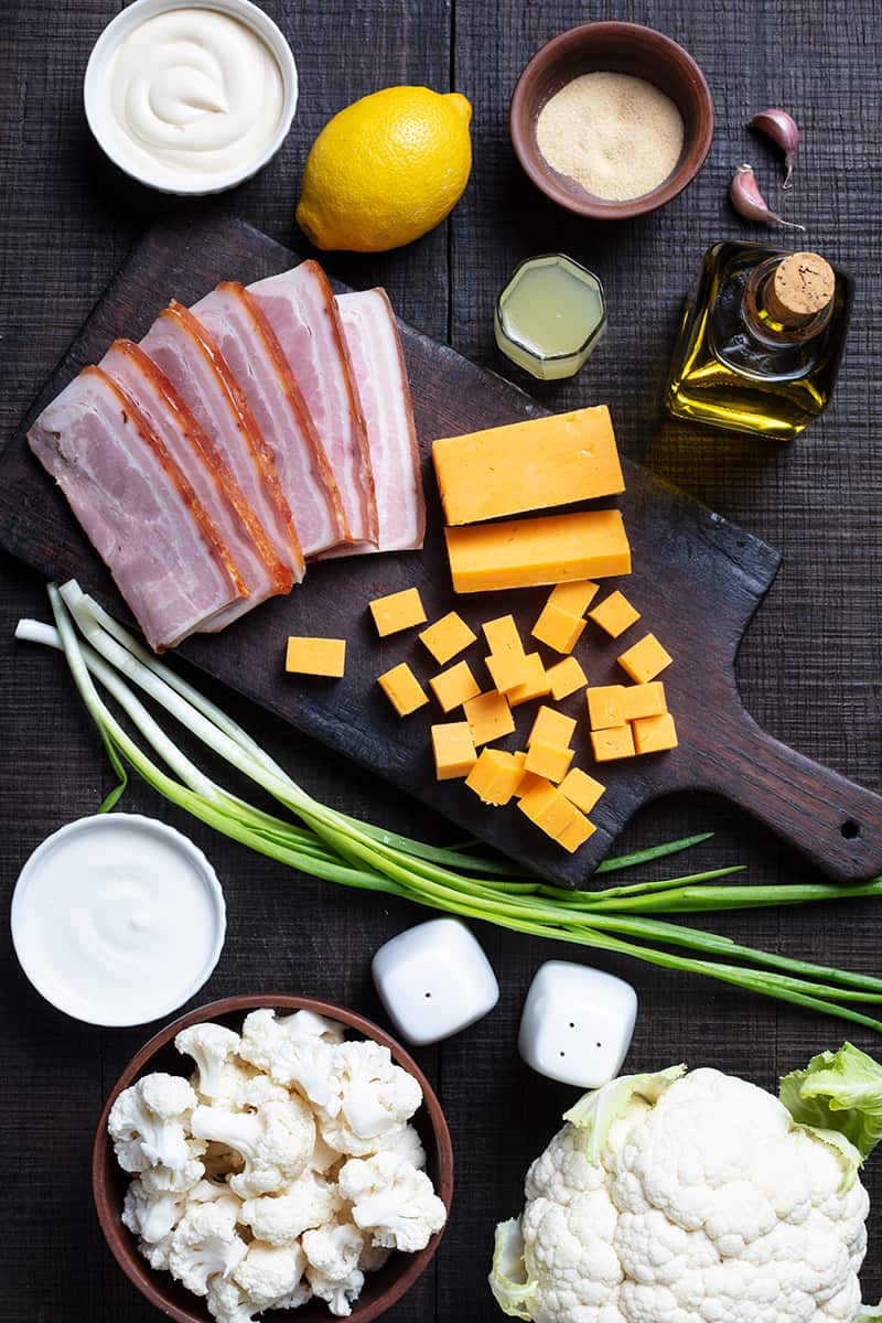 Cauliflower Salad ingredients on wooden chopping board and wood background