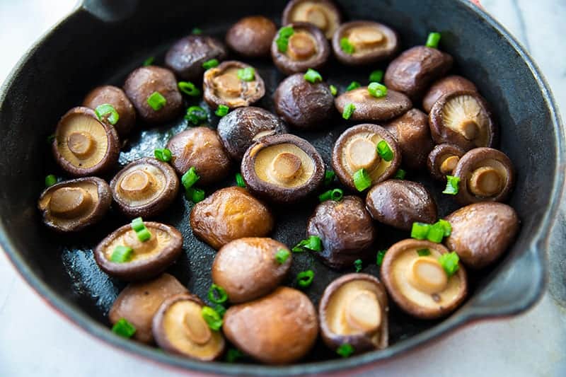 medium sized skillet with Shiitake Mushrooms garnish with green onions