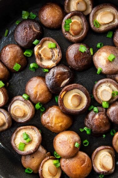 close up skillet with Shiitake Mushrooms garnish with green onions