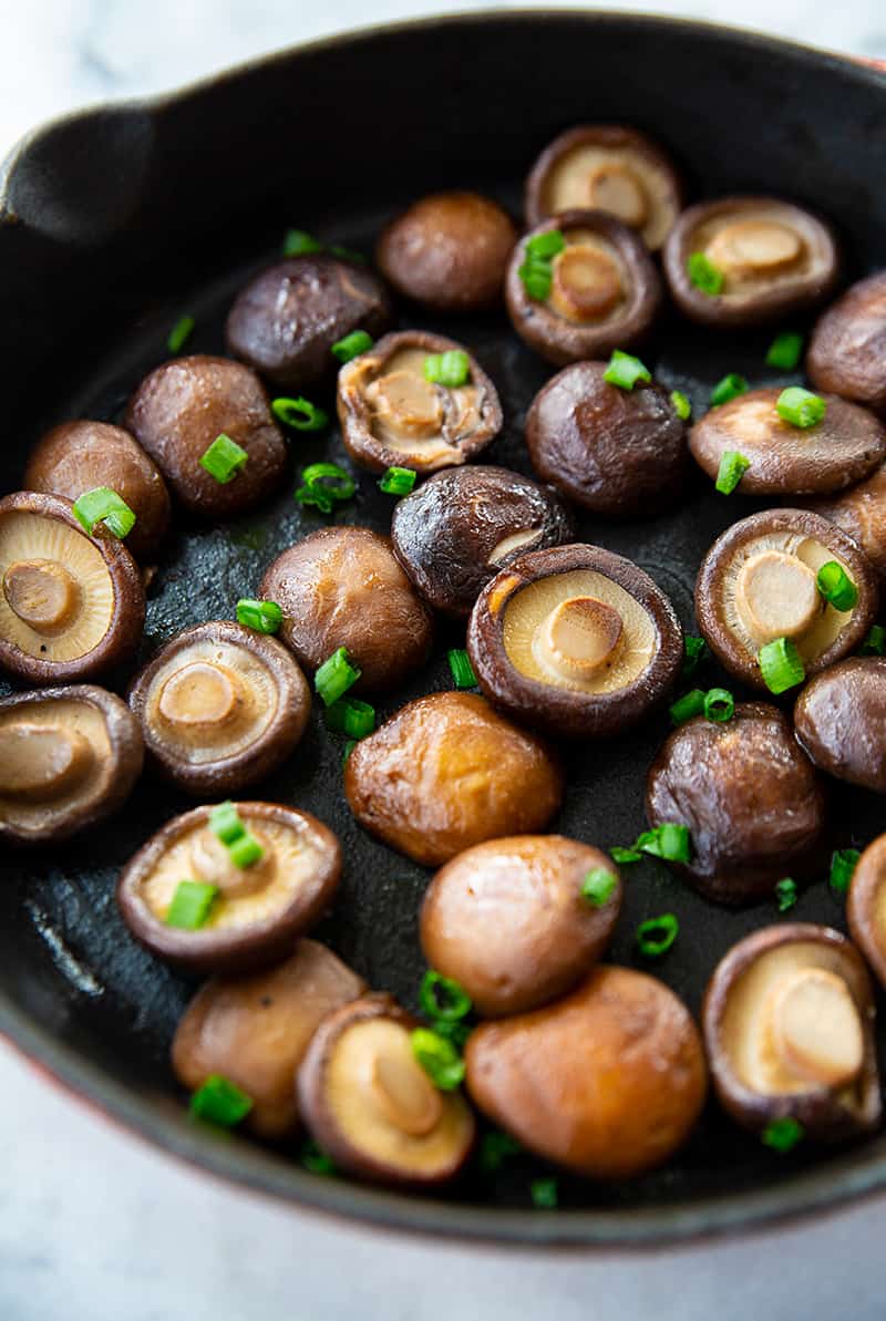 close up skillet with Shiitake Mushrooms garnish with green onions
