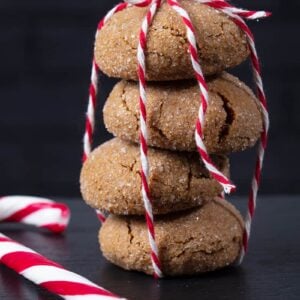 close up stack of Molasses Cookies tied with red and white ribbon, Christmas candy bar on side