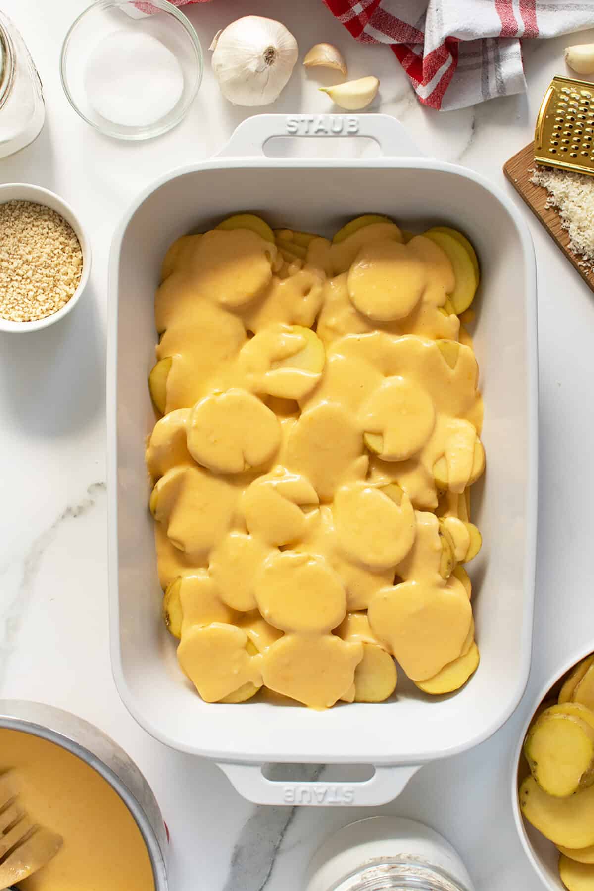 potatoes au gratin raw potatoes in a baking pan