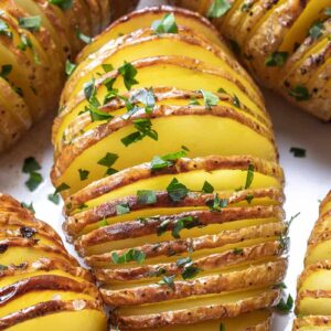 close up Hasselback Potatoes sprinkled with parsley flakes