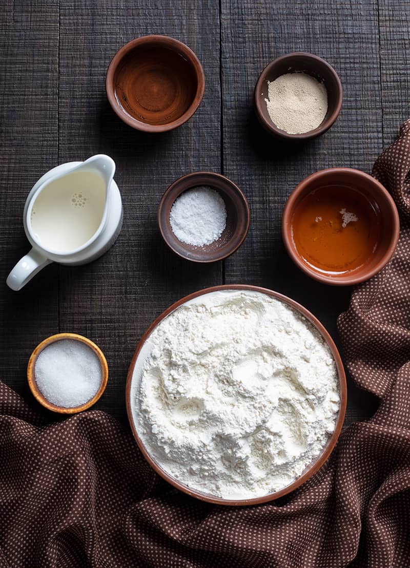 top down shot of Parker House Rolls ingredients on a wooden background with brown polka dot tablecloth