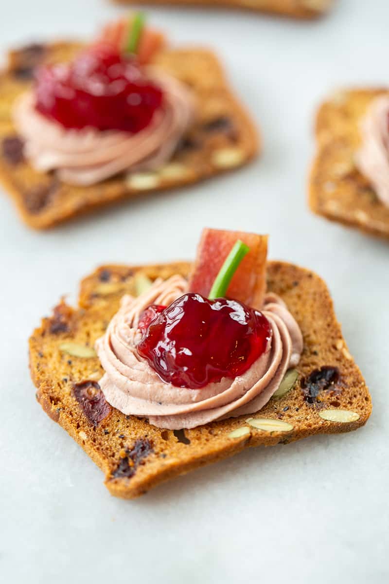 close up Classic Liver Canapé with sour cherry jam and chopped chives