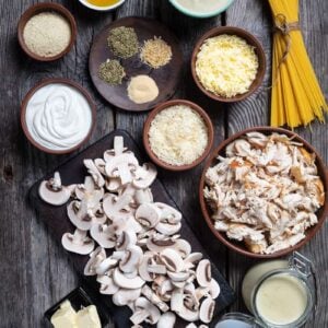 Ingredients are mise on place for making chicken tetrazzini on a wood background