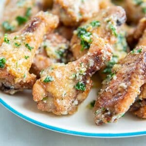 Garlic Parmesan Chicken Wings on a white plate with blue edge