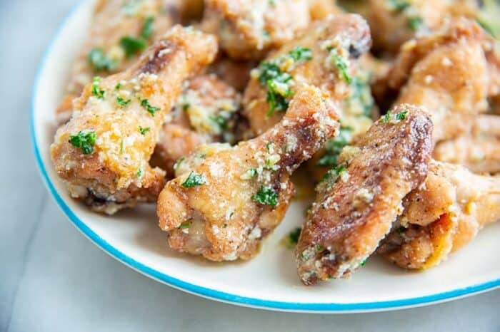 Garlic Parmesan Chicken Wings on a white plate with blue edge