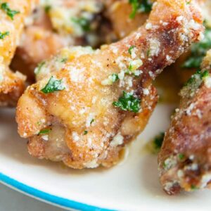 close up of one garlic Parmesan chicken wing garnished with green parsley