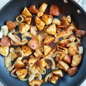 crispy pan fried potatoes and onions with paprika in a medium sized skillet