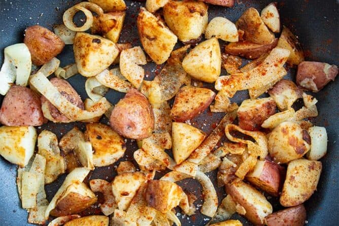 crispy pan fried potatoes and onions with paprika in a medium sized skillet